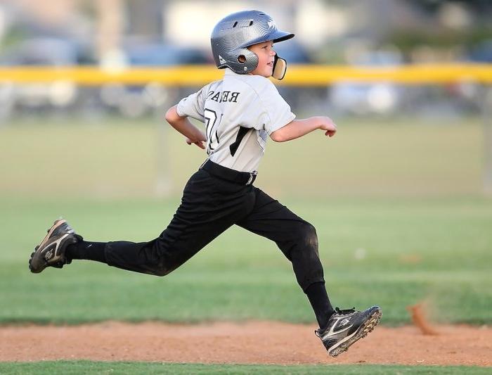 A boy running around a baseball diamond